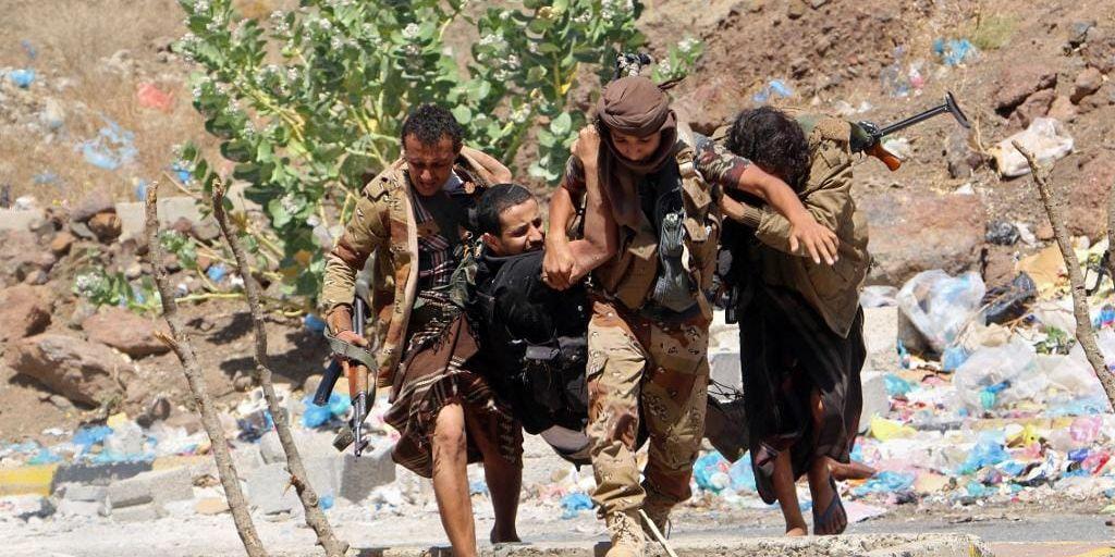 Lokal milis bär en skadad kamrat efter strider mot Huthirebeller i Taiz i fredags.